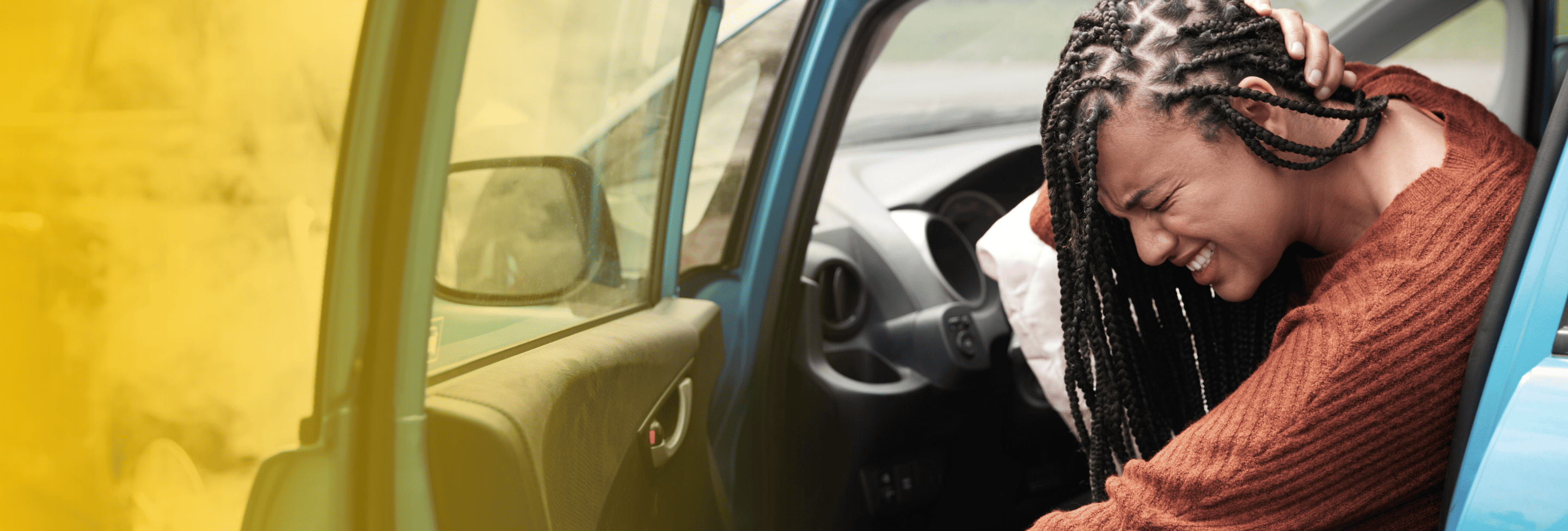 Woman clutching neck in vehicle after car crash