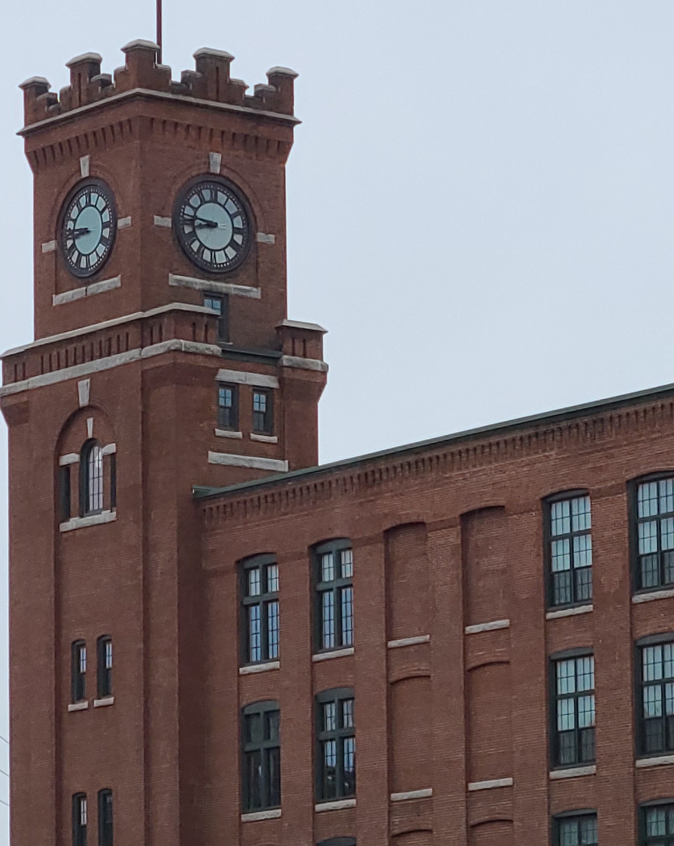 Photo of a brick clocktower taken from the ground looking up, with a cloudy sky in the background; the clock reads 9:45, and the top and bottom of the building are cut off by the edge of the photo, presented by New Hampshire personal injury lawyer Attorney Buckley